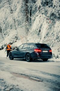 BMW 3er Touring auf schneebedeckter Waldstraße im Winter – Panne Gefahr